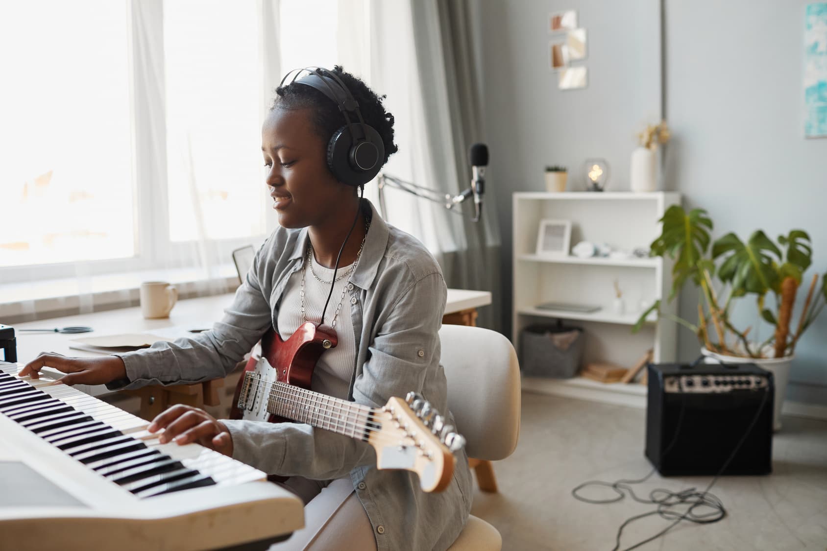 Musician composing on a keyboard in a home studio